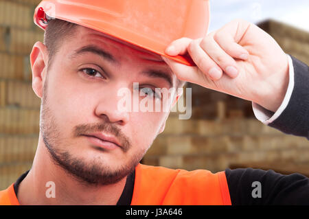 Close-up Portrait des jungen Ingenieurs mit Schutz Helm posiert auf Baustelle Stockfoto