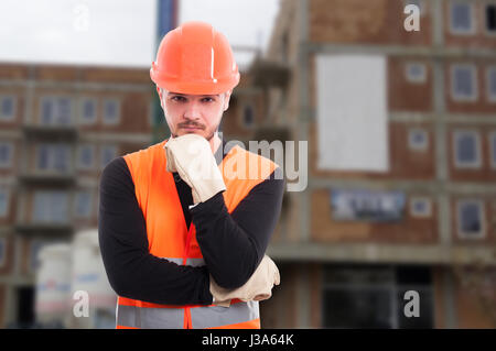 Nachdenklich männlichen Ingenieur draußen vor dem Gebäude tragen Schutzausrüstung Stockfoto