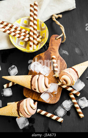 Schokolade und Karamell Eis mit Waffeln, geschmolzene Schokolade topping, Eiswürfel, Sommer erfrischende desserts Stockfoto
