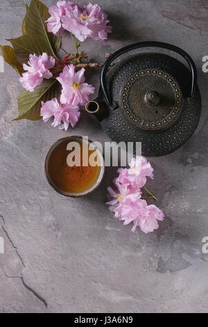 Teekanne und Tasse Tee mit Blüten Zweig Stockfoto