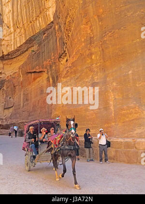 Pferdekutsche mit Touristen in die Siq in Petra. Stockfoto