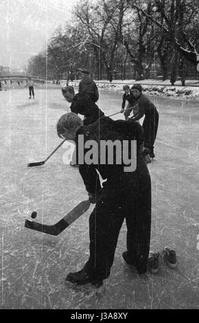 Kinder spielen Eishockey auf dem zugefrorenen Nymphenburger Kanal, 1955 Stockfoto