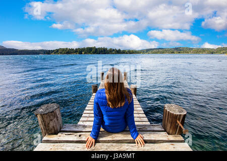 Mädchen sitzen auf einem Pier. See-Moreno, Bariloche, Argentinien. Stockfoto