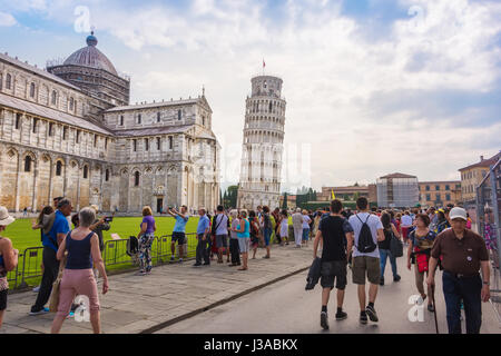 Pisa, Italien - 9. Juni 2016: Touristen versammeln sich auf dem Platz der Wunder in Pisa, der schiefe Turm von Pisa und die mittelalterliche Kathedrale des Bogens zu sehen