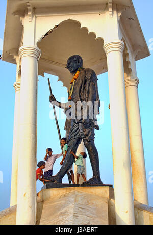 Mahatma Gandhi-Statue an der Küste von Pondicherry, Indien, mit Kindern spielen. Stockfoto