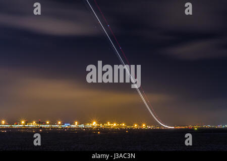 Lichtspur eines Start Flugzeug vom internationalen Flughafen Stockfoto