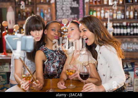 Glücklich Freundinnen nehmen Selfie gedrückter Weingläser im pub Stockfoto