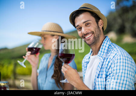 Porträt von lächelnden Mann mit Rotwein im Glas Stockfoto