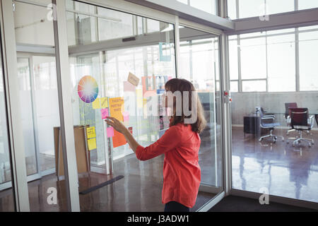 Seitenansicht der Geschäftsfrau Analyse Strategien in Kreativbüro Stockfoto