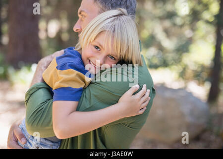 Porträt eines lächelnden jungen umarmte Vater im Wald Stockfoto