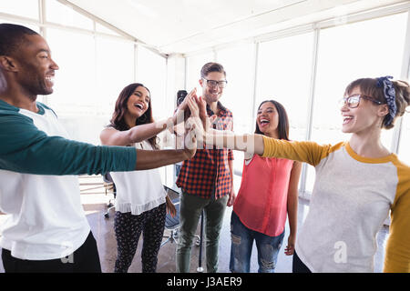 Glückliche Unternehmen Menschen hohe Fiving stehend im Büro Stockfoto