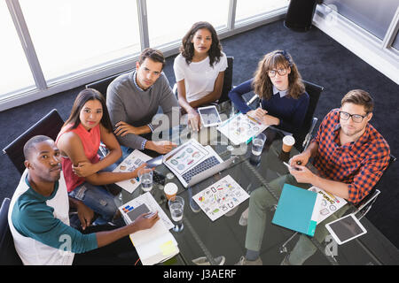 Hohen Winkel Porträt von Geschäftsleuten, die während der Sitzung in im Büro am Schreibtisch sitzen Stockfoto