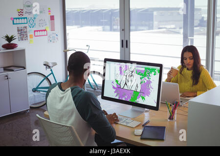 Grafik-Designer mit Computer und Laptop während der Arbeit in Kreativbüro Stockfoto