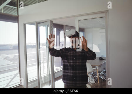 Junger Geschäftsmann gestikulieren und erleben Sie virtual Reality im Büro Stockfoto