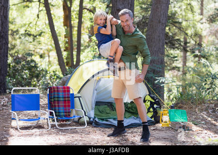 Porträt der verspielte Vater mit Sohn durch Vorzelt auf Campingplatz Stockfoto