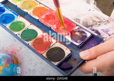 Aquarellfarbe auflösen in Wasser mit Wasser bedeckt Stockfoto