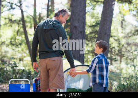 Rückansicht von Vater und Sohn Hand in Hand beim Wandern im Wald Stockfoto