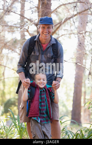 Porträt von verspielten Vater und Sohn im Wald genießen Stockfoto