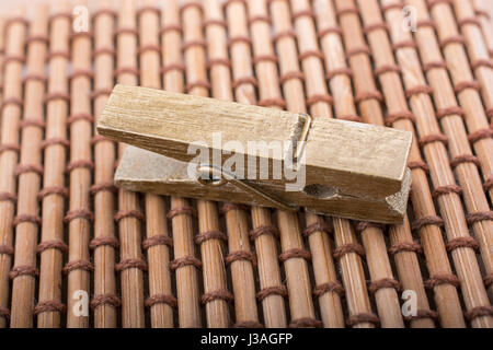 Kleine hölzerne Wäscheklammer auf Stroh Hintergrund platziert Stockfoto