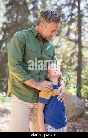 Vater und Sohn sahen einander stehend im Wald Stockfoto