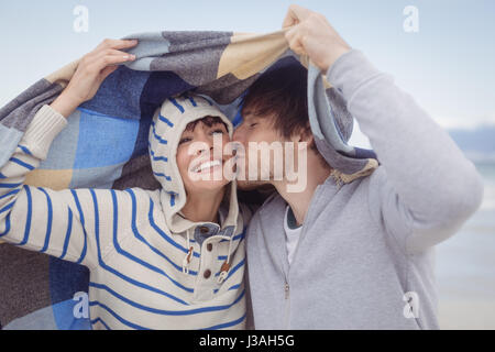 Junger Mann küssen seiner Freundin am Strand im winter Stockfoto