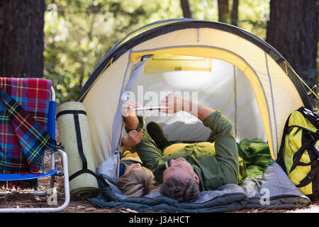 Vater und Sohn mit digital-Tablette und entspannen Sie im Zelt am Campingplatz Stockfoto
