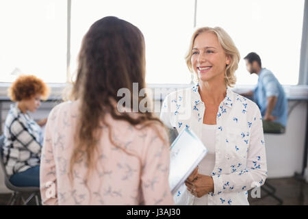 Lächeln, Geschäftsfrau, die Interaktion mit weiblichen Collaeague im Büro Stockfoto