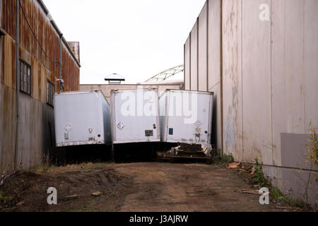 Ort des letzten Parkplatz der Alten trockenen van Auflieger zwischen zwei alten rostigen industrielle Hangars in einem Industriegebiet Stockfoto