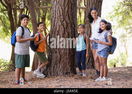 Glückliche Schüler und Lehrer während der Exkursion durch Baum stehen Stockfoto