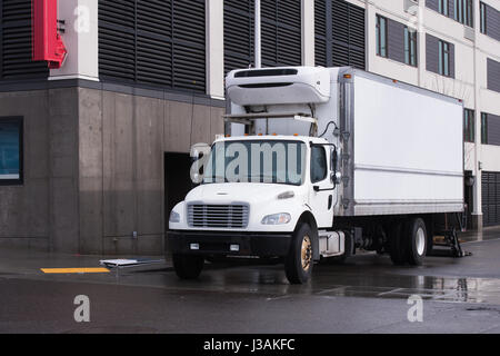 Modernes weißes Semi Truck von Mitte Pflicht und Größe mit Tag cab und Kühlschrank auf Box Auflieger für den lokalen Transport und Lieferung Stockfoto