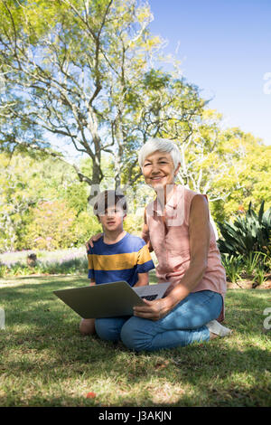 Porträt der Großmutter und Enkel mit Laptop im park Stockfoto