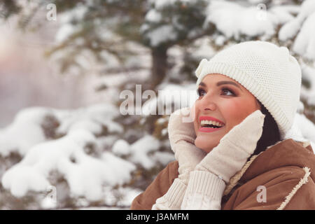 Schöne Frau im Winterpark Gesicht mit Fäustlinge schließen und Lächeln auf den Lippen. Selektiven Fokus, Textfreiraum, Jahrgang getönten Bild Stockfoto