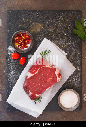 Rohes Fleisch Steak auf Schiefer und Gewürze, Zubereitung von Speisen.  Ansicht von oben, Leerzeichen Stockfoto