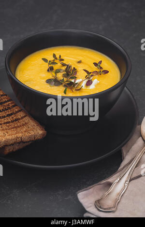 Kürbissuppe mit Blauschimmelkäse, Thymian und Scheibe Brot. Makro, Tiefenschärfe, Leerzeichen Stockfoto