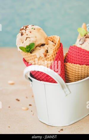 Caramel chocolate Chip Eis Waffelhörnchen, rustikale Oberfläche. Tiefenschärfe, Leerzeichen Stockfoto