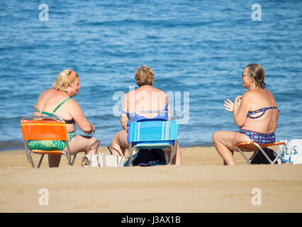 Drei ältere Spanierin im Chat am Strand nach Morgenschwimmen. Stockfoto