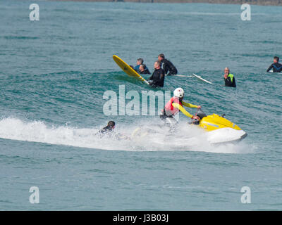 Newquay, Großbritannien. 4. Mai 2017. Rettung auf See von Rettungsschwimmern bewacht. 4. Mai 2017. Ein Mann und eine Frau auf Surfbretter sind durch die Felsen auf dem South by RNLI Rettungsschwimmer auf einen Jetski am Fistral Strand fistral Newquay, Cornwall, UK aus der Brandung gerettet.  Robert Taylor/Alamy Live-Nachrichten Stockfoto