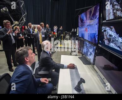 Seine Majestät der König von Schweden König Carl XVI. Gustaf, center, versucht sich an einem abgelegenen Roboterarm unter dem wachsamen Auge von Benjamin Reed, stellvertretender Direktor der Division der SAT-Service Projekte Division bei einem Besuch von einer schwedischen Delegation des Goddard Space Flight Center 3. Mai 2017 in Greenbelt, Maryland. Stockfoto