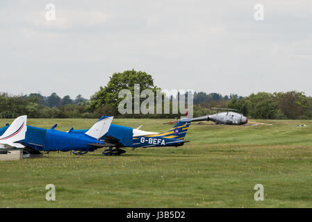 Booker, Buckinghamshire, England. 5. Mai 2017. 3 Männer, 2 sind ernsthaft verletzt worden, als der Hubschrauber, die, den Sie flogen am Wycombe Air Park (auch bekannt als Booker Airfield) Notdienste aus Buckinghamshire Feuer und Rettungsdienst, Thames Valley Police und South Central Rettungsdienst, die erste Szene stürzte, eilte zu der Absturzstelle bei ca. 09:30BST waren. Ein Luft-Krankenwagen nahmen ebenfalls Teil. Im Bild: Die beschädigten Hubschraubers legt auf seiner Seite. Bildnachweis: Peter Manning/Alamy Live-Nachrichten Stockfoto