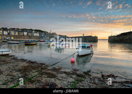 Sonnenaufgang über Boote im Hafen von Mousehole an der kornischen Küste Stockfoto