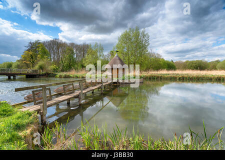 Ein Strohdach Fischer Hütte und Aal fallen am Fluss Test am Longstock in Hampshire Stockfoto