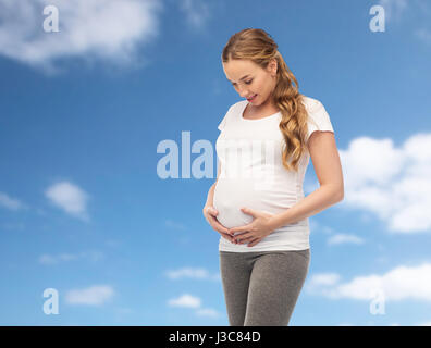glücklich schwanger Frau ihren dicken Bauch zu berühren Stockfoto