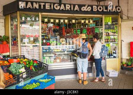 Markt für junge Frauen, Blick auf zwei junge Frauen, die Softdrinks von einem Händler im historischen Mercado do Bolhao im Zentrum von Porto, Portugal, kaufen. Stockfoto