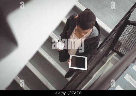 Erhöhte Ansicht der Geschäftsfrau Blick auf digital-Tablette auf Schritte Stockfoto