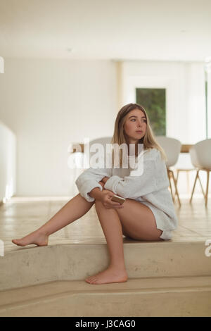 Schöne Frau mit Handy zu Hause Stockfoto
