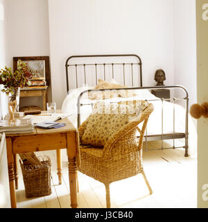 Schlafzimmer mit Schreibtisch und Wicker Sessel. Stockfoto
