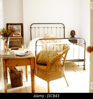 Schlafzimmer mit Schreibtisch und Wicker Sessel. Stockfoto