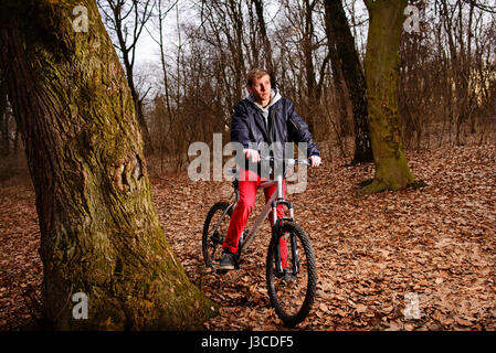 Radsportler, die das Fahrrad auf einem Weg im Sommer Wald. Stockfoto