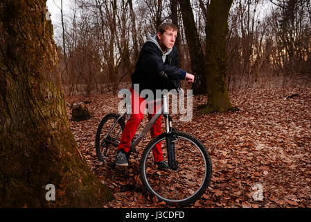 Radsportler, die das Fahrrad auf einem Weg im Sommer Wald. Stockfoto