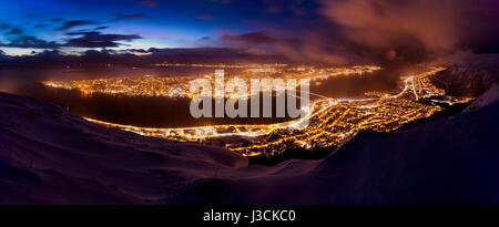 Schöne und bunte Panoramablick über die Stadt Tromsø, Norwegen Troms, während der Dämmerung. Ein Winter-Schneesturm ist eingehend in das Tal von Tromsø, Flugzeit Stockfoto